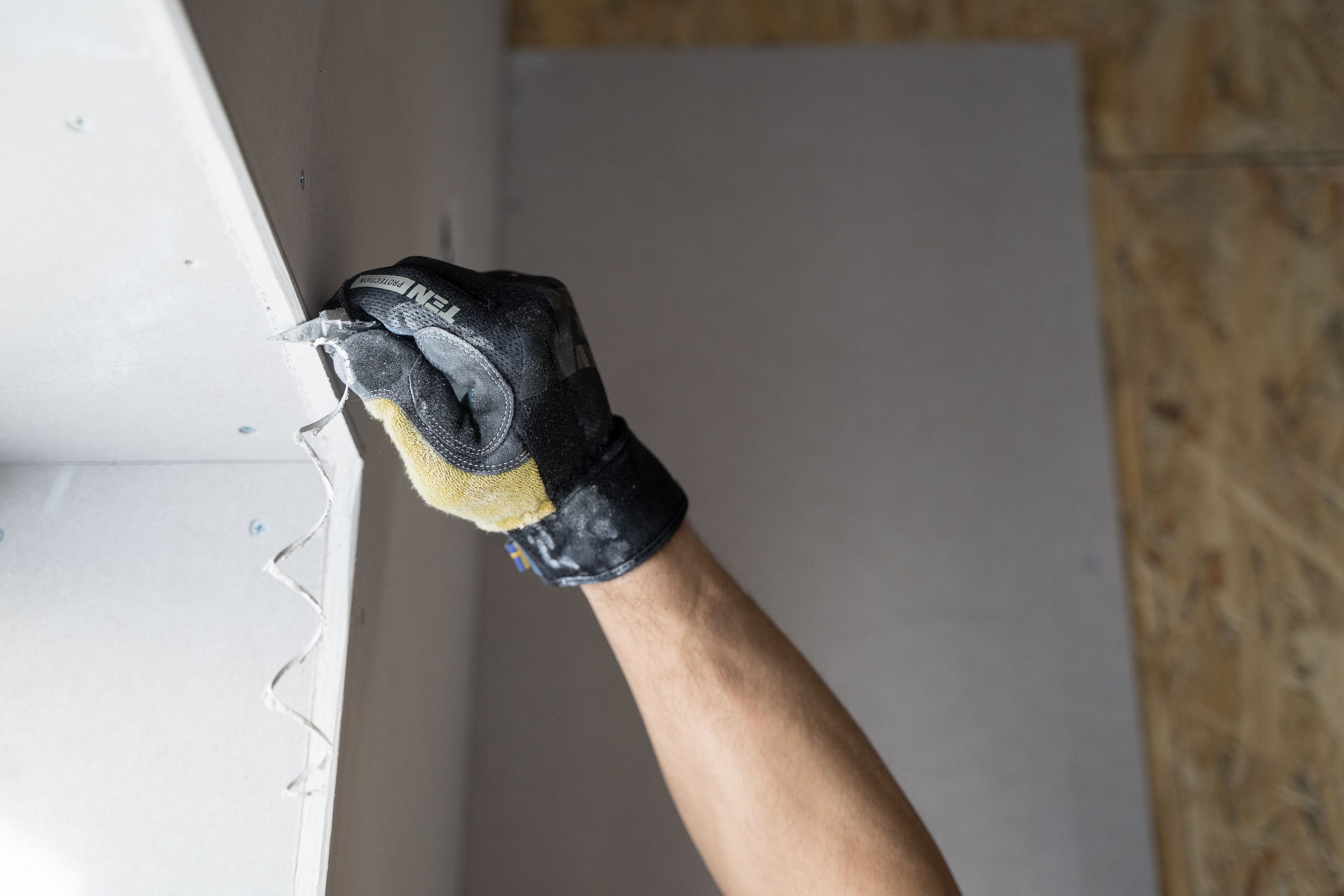 Main appliquant du plâtre sur mur intérieur