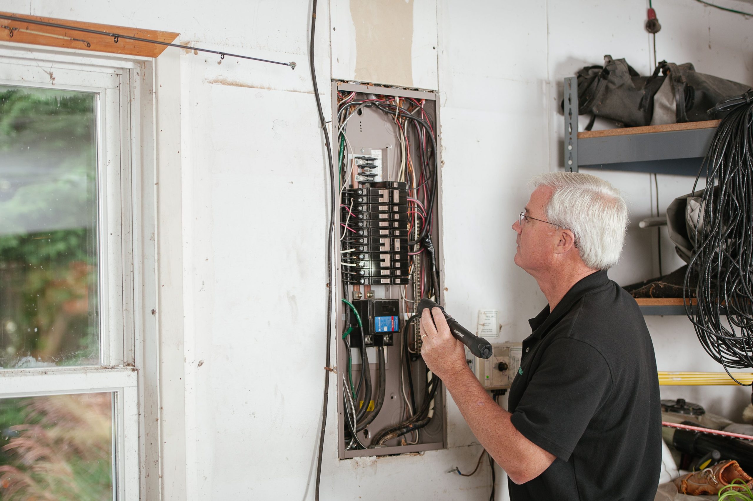 Électricien inspectant tableau électrique résidentiel sécurité