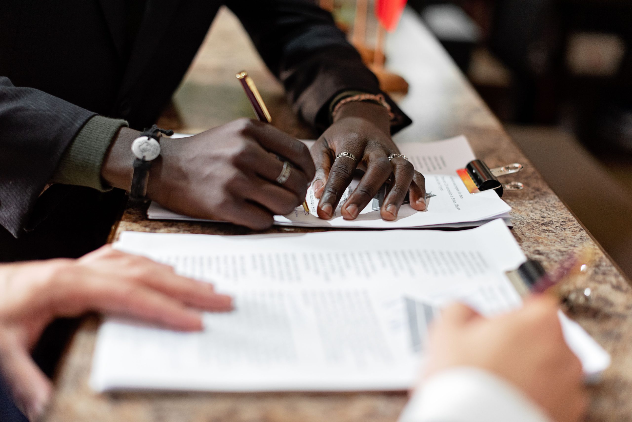 Mains signant des documents en contexte professionnel