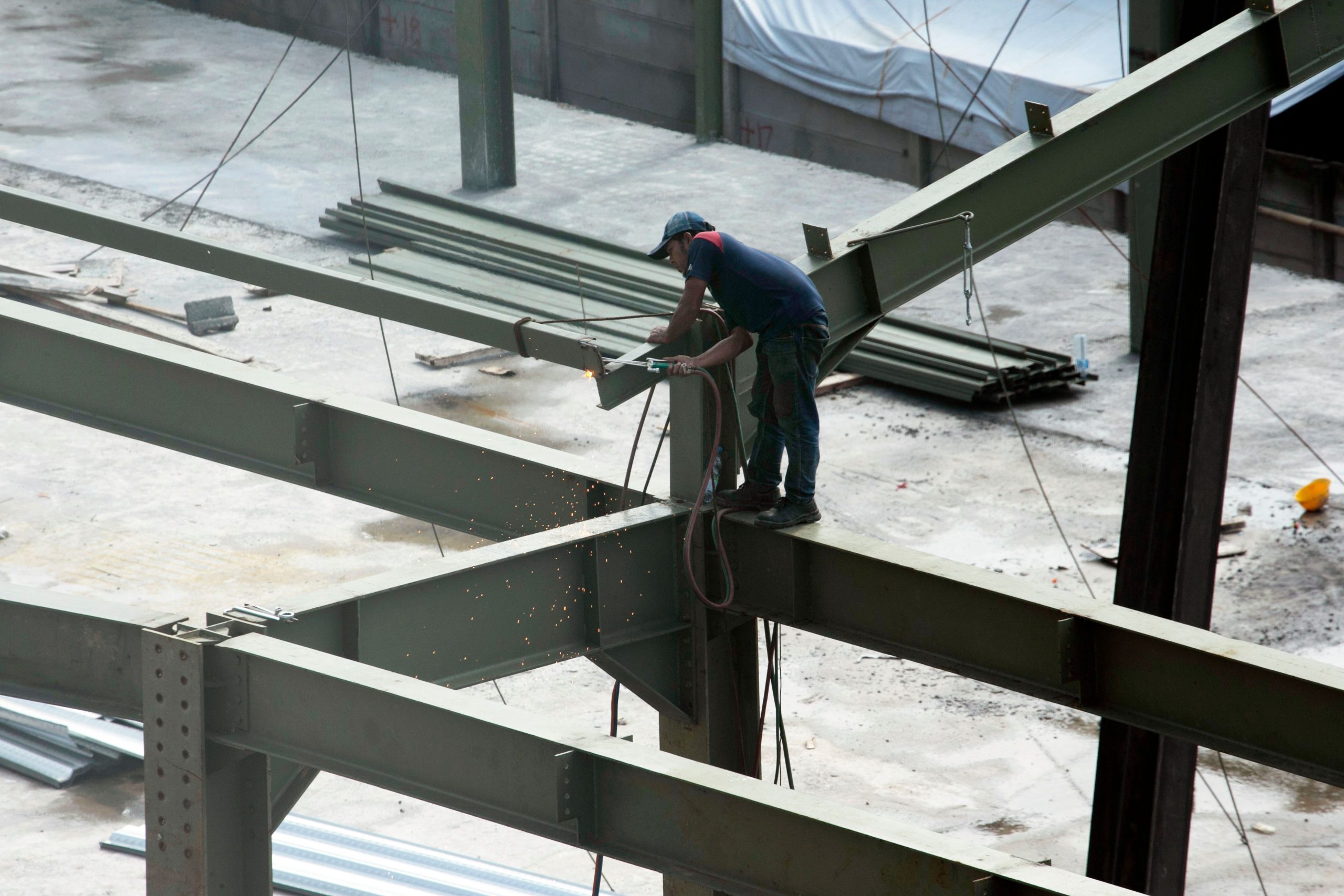 Ouvrier soudant des poutrelles acier sur chantier