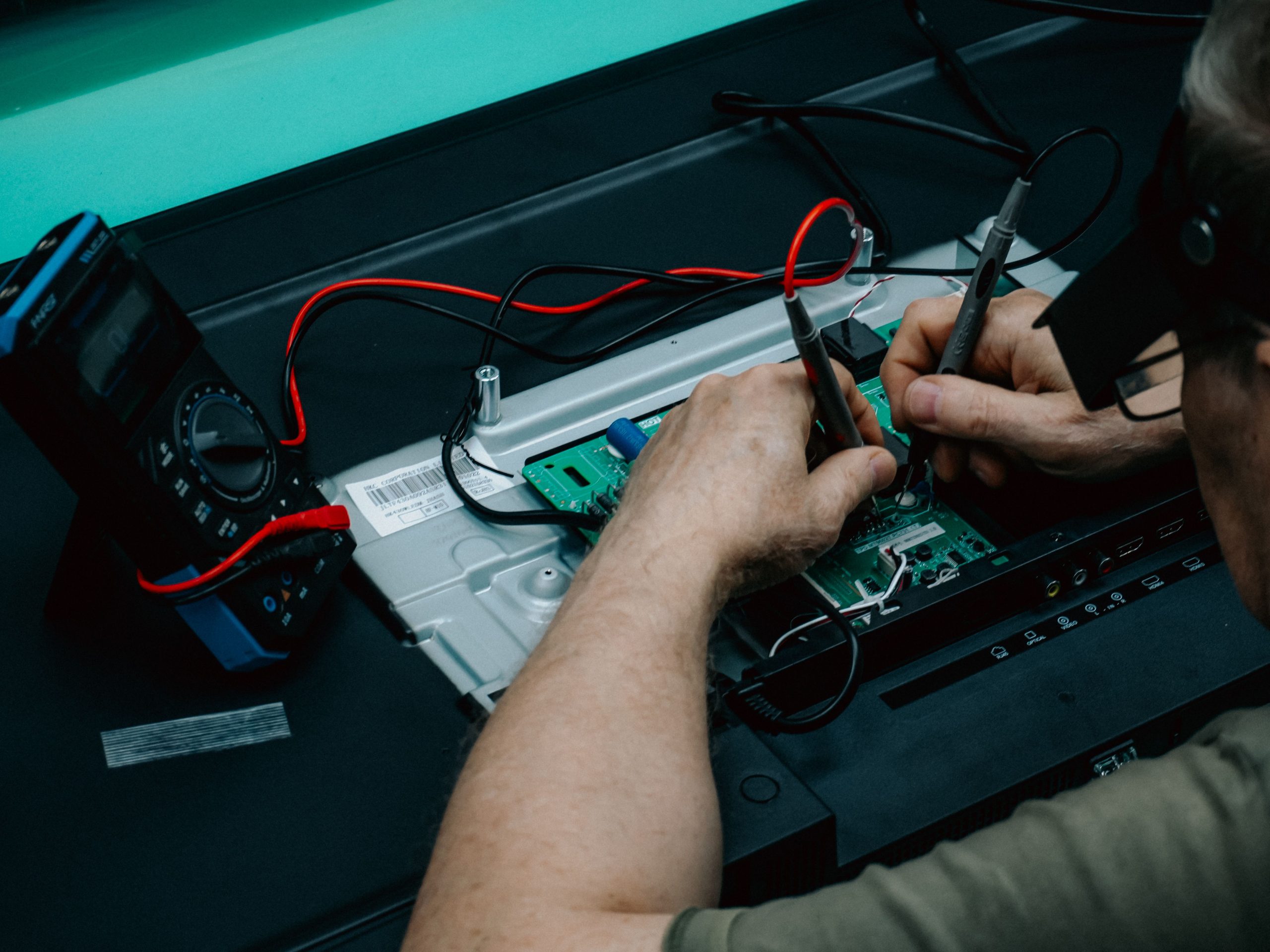Technicien réparant circuit avec multimètre